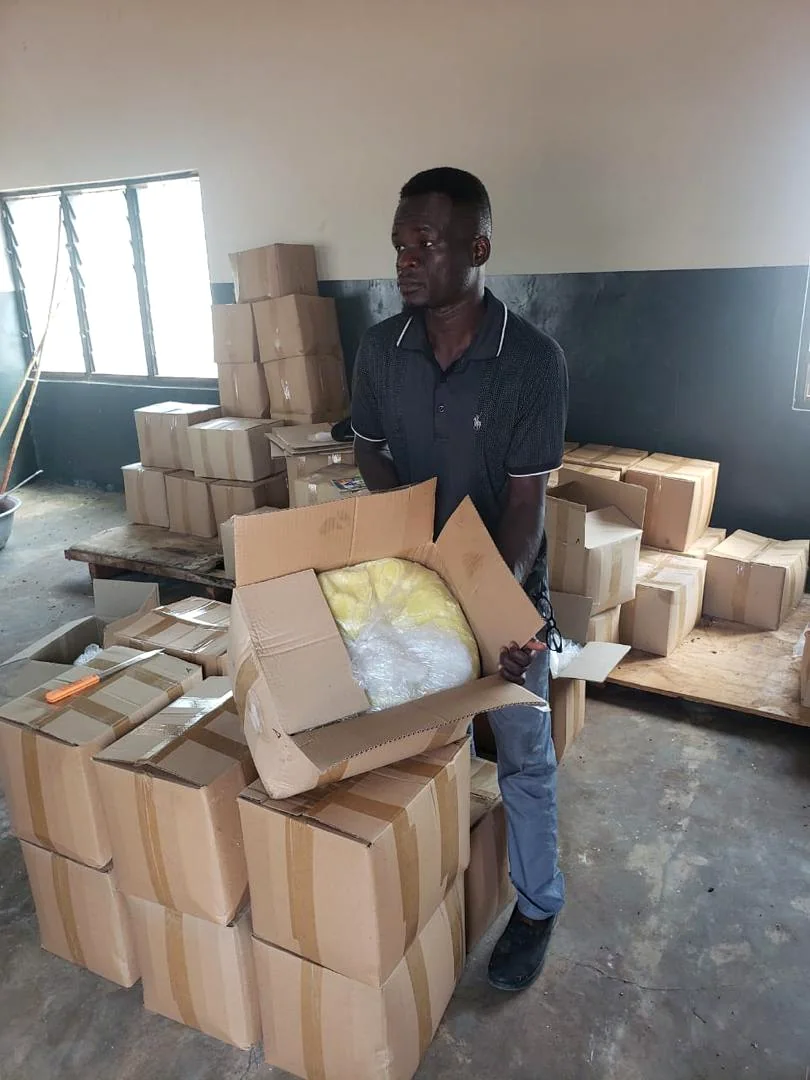 Packaged natural product being handled among boxed inventory